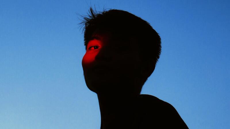 person's silhouette but with red light shining over one eye