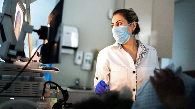healthcare professional looking at computer monitor while performing endoscopy on patient
