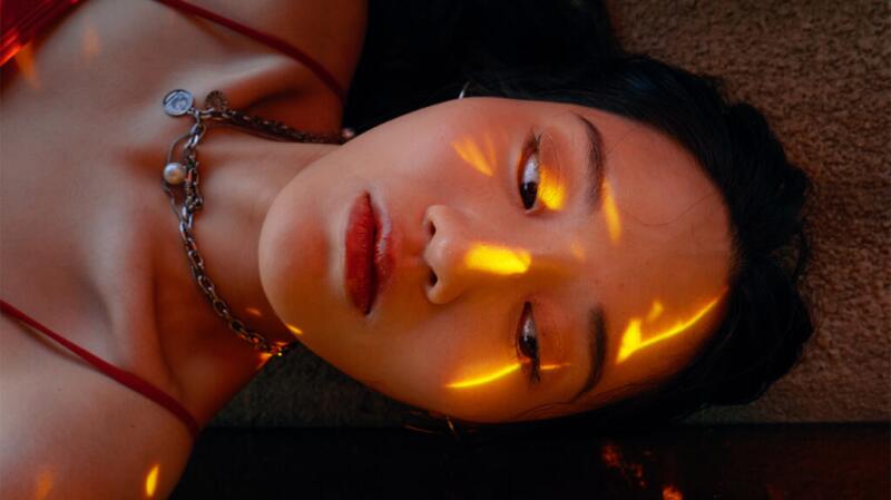 A young woman is bathed in light.