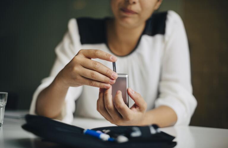 Woman checking blood sugar on finger