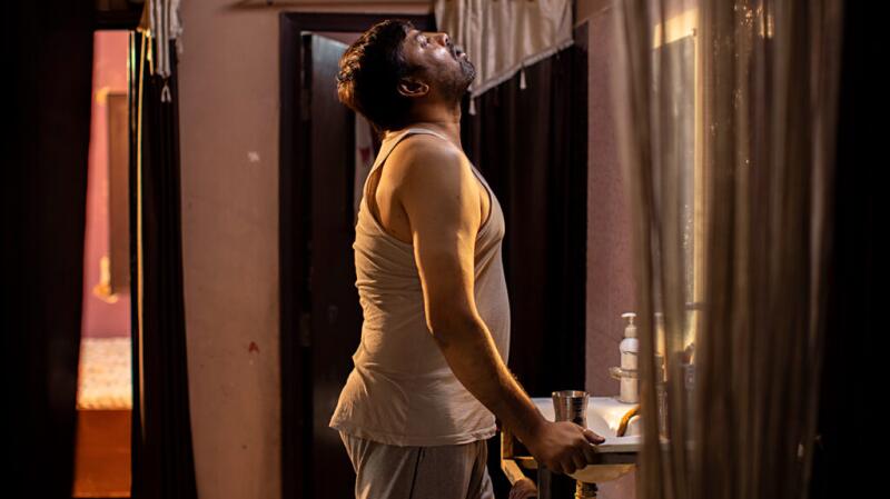 A man standing at the sink and gargling water