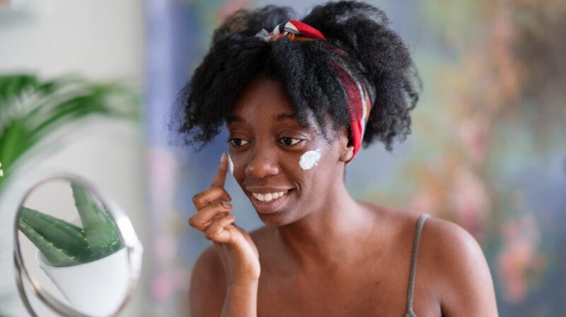 A woman applying facial cream