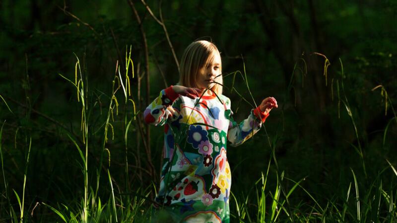 A child is playing in the grass.