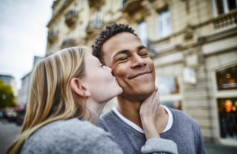 Young woman kissing boyfriend in the city