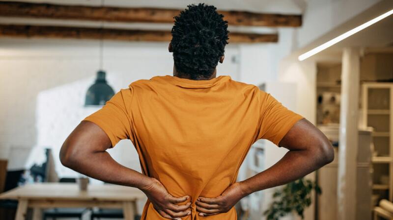 a person is grabbing their back