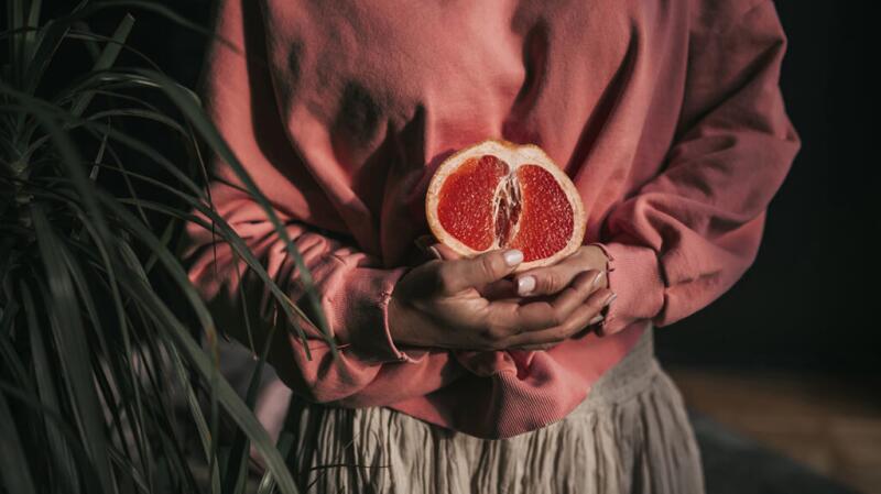 Female holding half a grapefruit