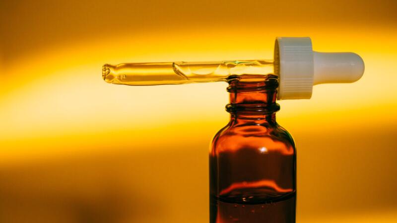 there is a bottle of CBD oil against a yellow background
