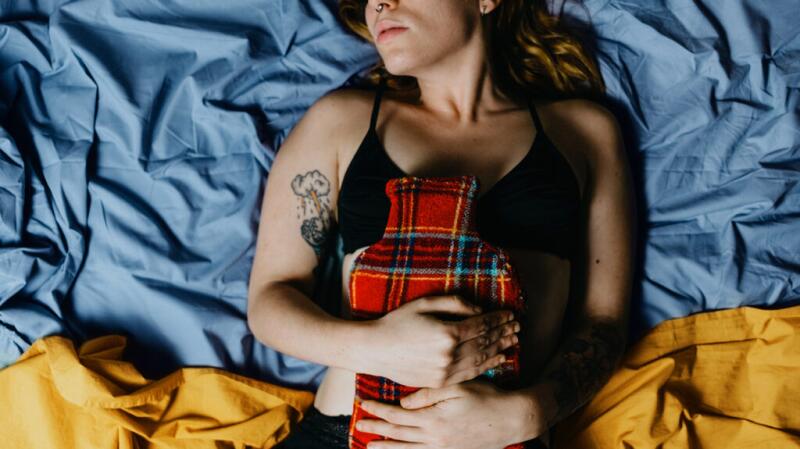 woman holding hot pack over stomach
