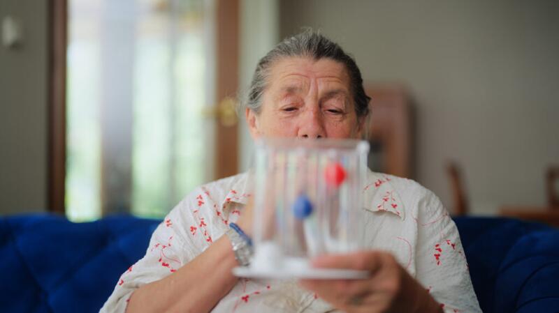 A woman using a spirometer