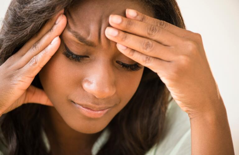 Woman frowning with head in hands