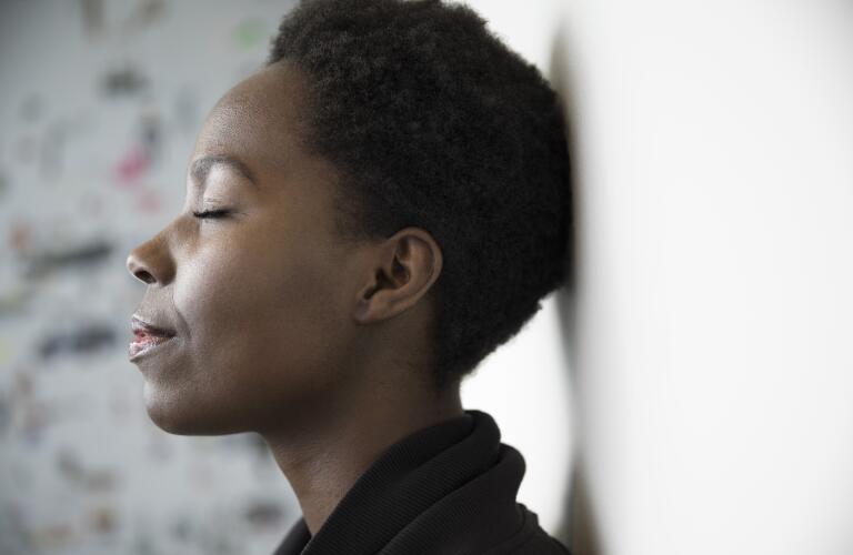 middle aged woman relaxing or meditating with eyes closed