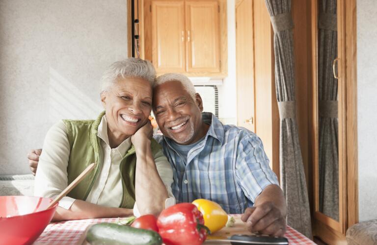 senior couple sitting at dinner table in front of healthy food