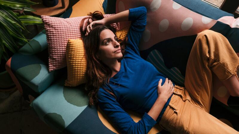 Women laying down on couch with hand on abdomen