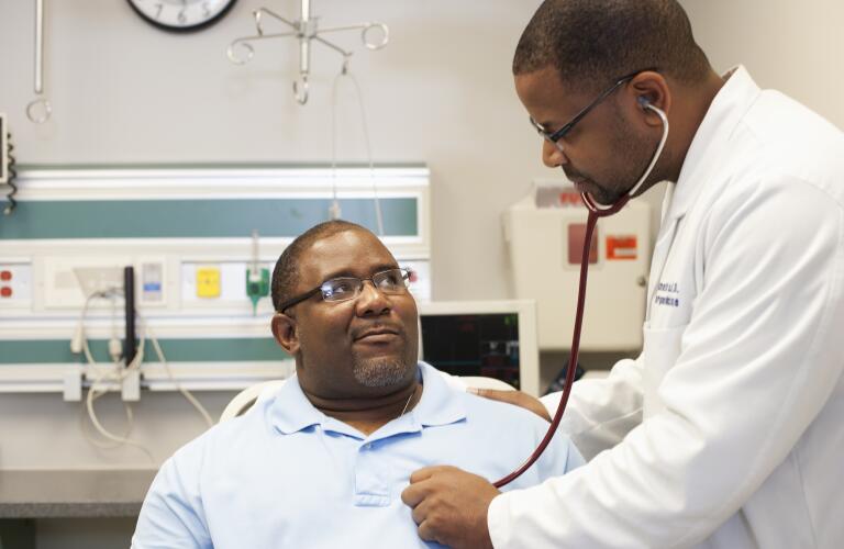 doctor listening to man's heartbeat