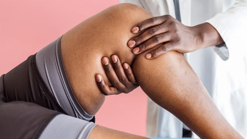 Doctor checking the muscles on a person's leg