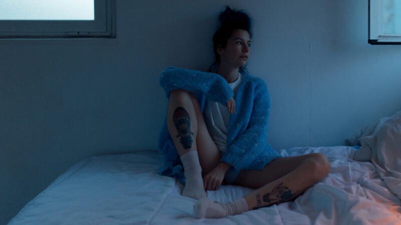 woman wearing t-shirt, underwear and sweater bed in a darkened room