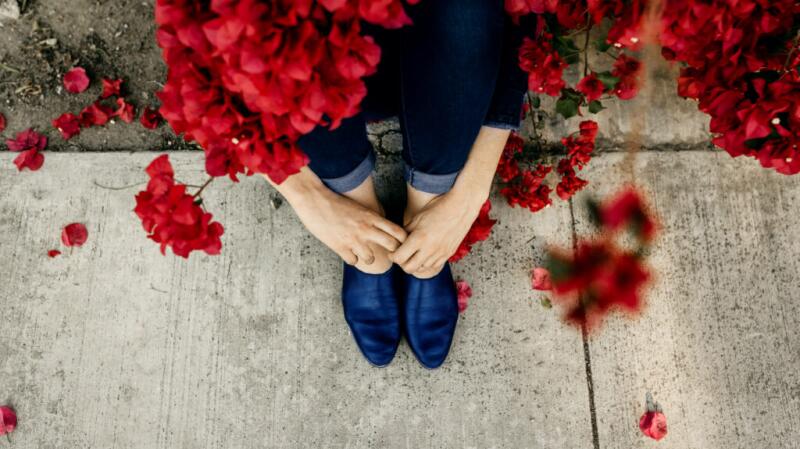 a person is sat holding their hands and feet
