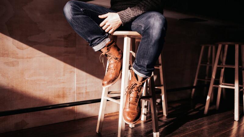 A man is sitting on a bar stool.