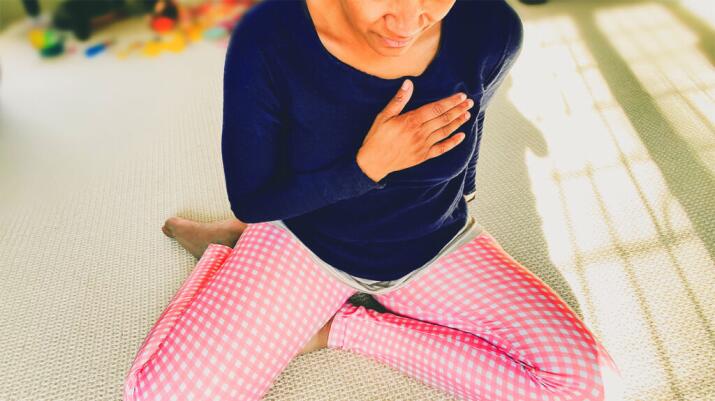 a woman wearing pink leggings has a hand on her chest