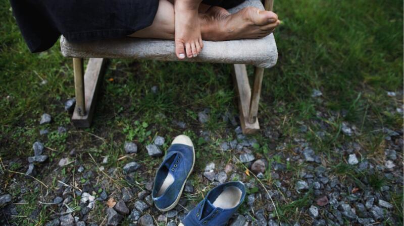 A person is sitting in a chair with their shoes off.