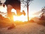 Close-up of Caucasian male runner on outdoor path at sunrise or sunset