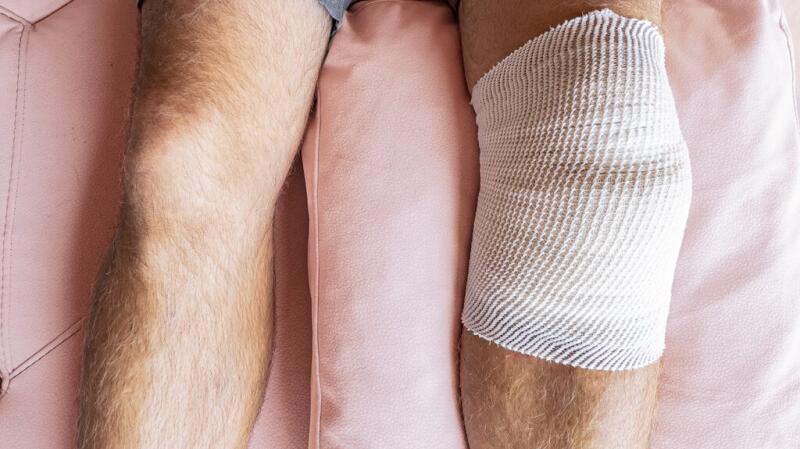 There is a closeup of a person with a bandage on their knee.