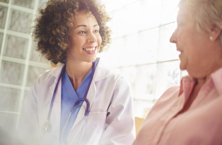 smiling female doctor talking to senior female patient