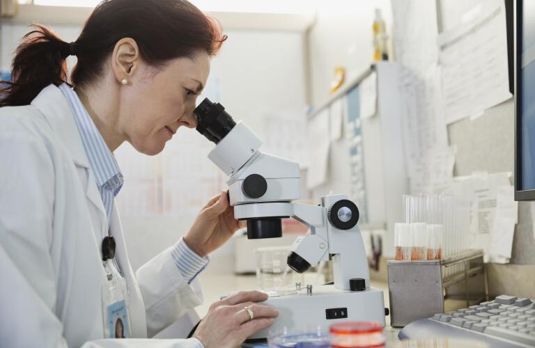 Doctor looking into microscope