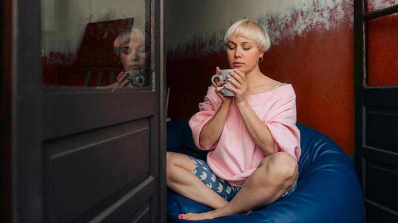 a woman with the flu is drinking tea
