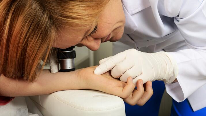 Doctor examining skin on a persons arm