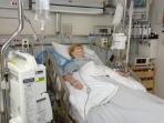 Mature female patient on respiratory ventilator in intensive care unit