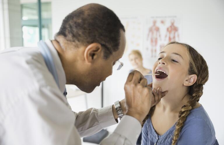 doctor-examining-girl-with-tongue-depressor