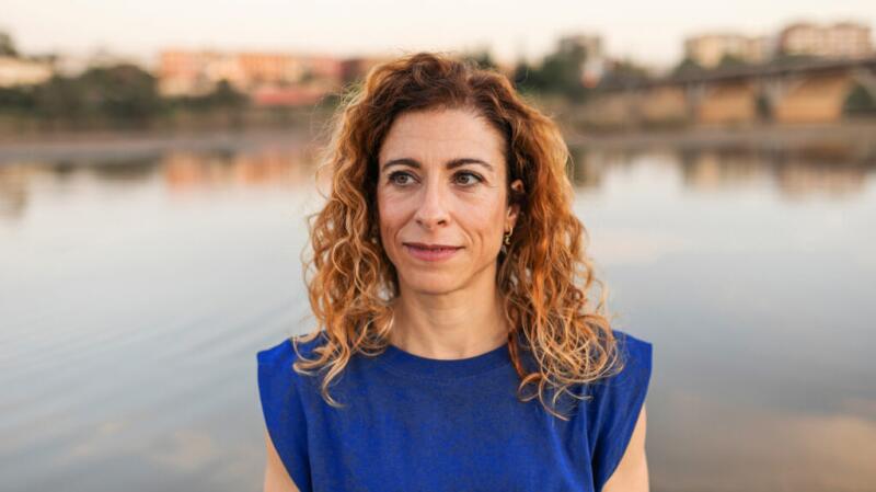 a woman is stood by some water