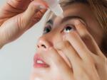 young woman applying medicine or saline drops in her eyes