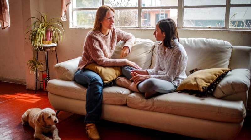 Adult and child sitting on a couch talking