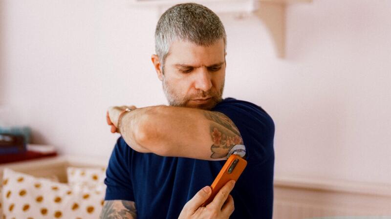 A man checking his glucose levels with his phone