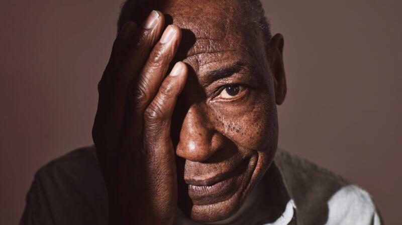 Man looking toward camera holding hand over right side of his face