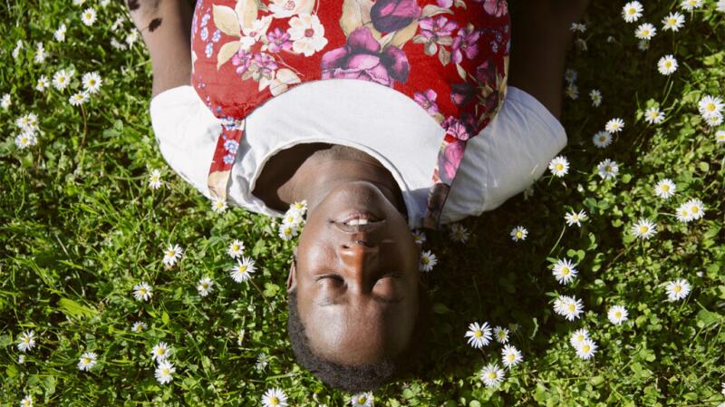 A woman is relaxing in the grass.