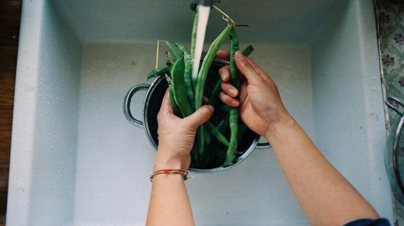 a person is washing vegetables in a sink