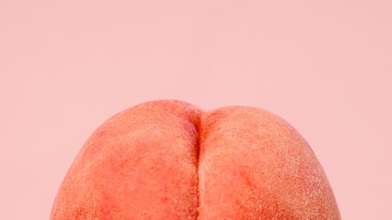there is a fresh peach against a pink background
