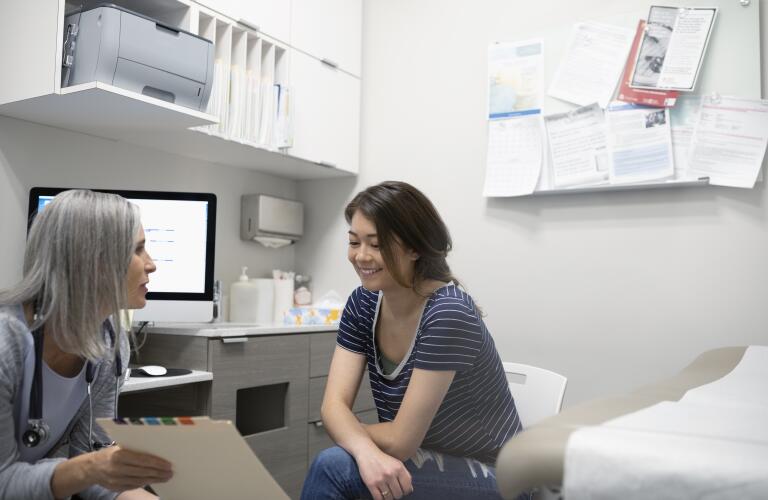 Young Asian American woman visiting female doctor