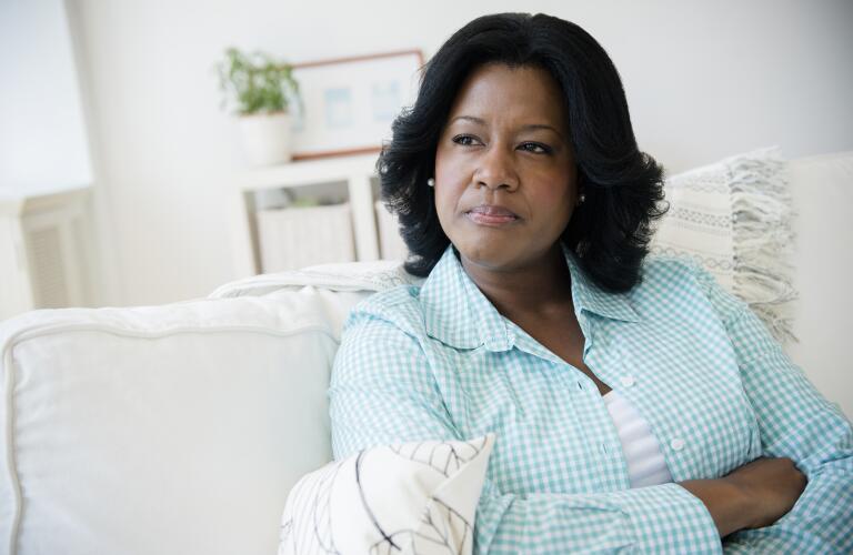 thoughtful woman sitting on couch