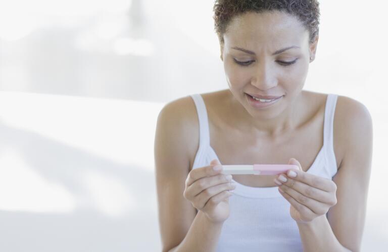 Worried woman looking at pregnancy test