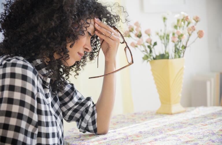 woman-with-migraine-headache-holding-glasses