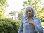 Older African American woman outside feeling chest pain or arrhythmia