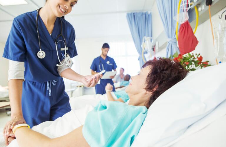 Nurse examining patient in hospital room