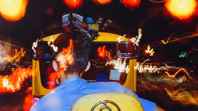 The back of a person's head and shoulders overlaid with blurry lights