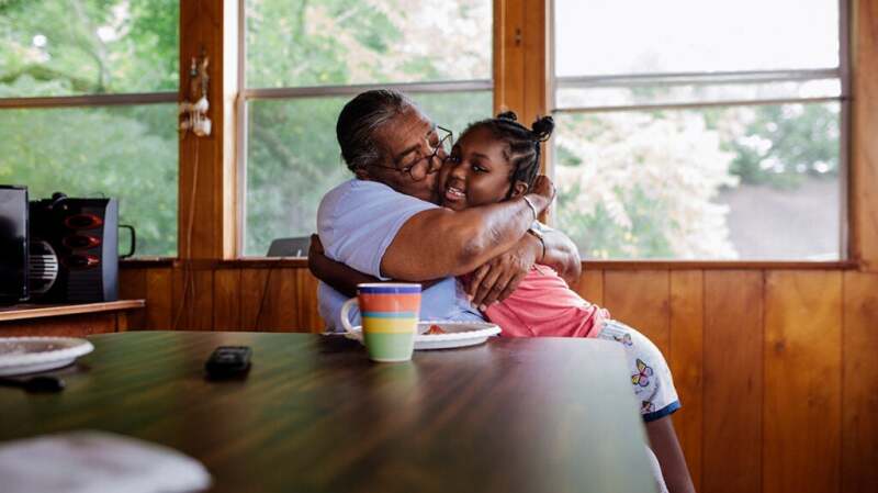 A grandmother hugging her granddaughter
