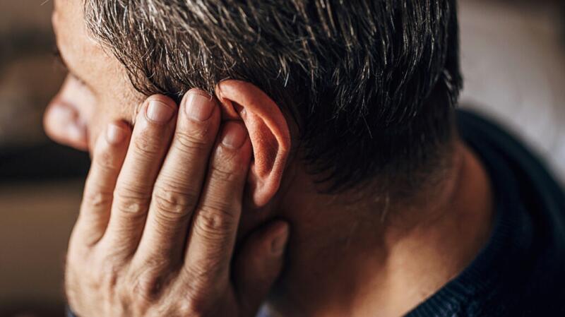 A man holding his hand to his ear