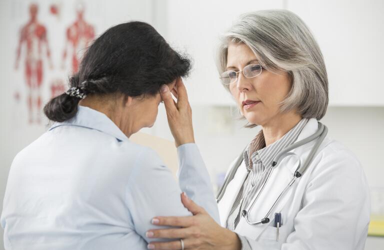 Female Caucasian doctor comforting patient with head pain